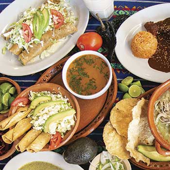 Mesa con flautas, consomé, enchiladas y mole