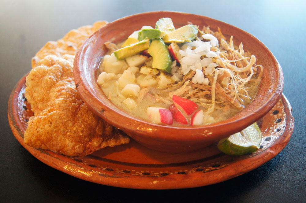 Pozole blanco con aguacate, chicharrón y rábano